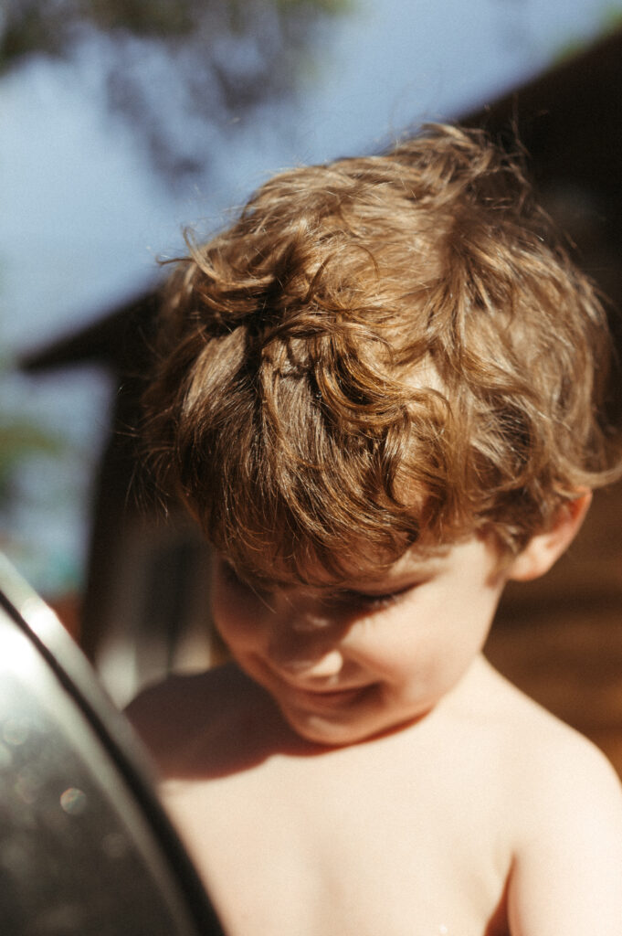 Toddler boy looking into a stainless steel mixing bowl.