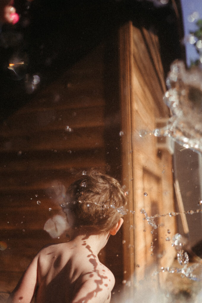 Water splashing on a toddler boy. 