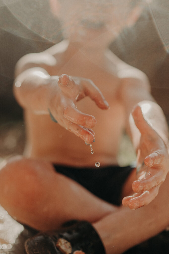 Toddler boy's wet hands pointing at the camera.