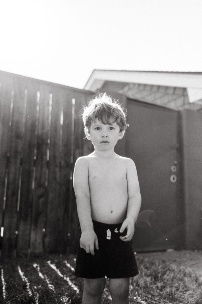 Toddler boy making a somber face at the camera. 